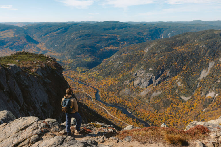 person standing at the summit of acropole des draveurs in quebec